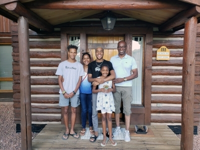 Family in front of a cabin at Camp Gunnison—The Way Household Ranch